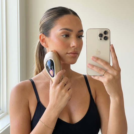 une femme ce prenant en photo qui tient dans la main l'épilateur à lumière pulsée Lumizia confort.